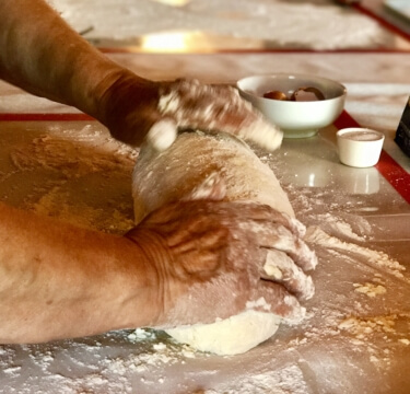 Yoga in Italy Cooking Class showing experienced hands making of dough for potato gnocchi. Yoga Retreat Italy